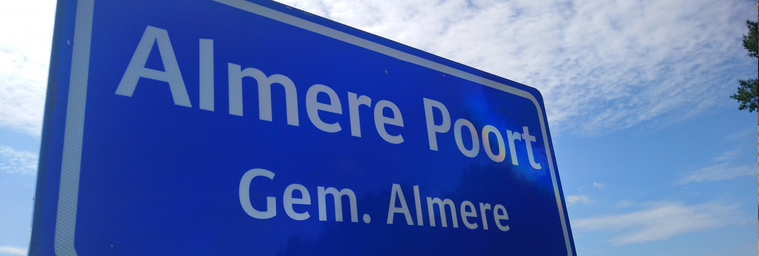 Blauwverkeersbord op de grens van Almere Poort
